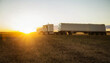 © Designpics - A grain transport truck sitting in a Canola field at sunset waiting for its next load; Legal, Alberta, Canada