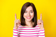 Closeup photo of young beautiful girl directing fingers up good news isolated on yellow color background