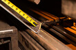 © Designpics - A tape measure measures length of a sheet metal component for material preparation; Innisfail, Alberta, Canada