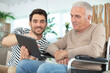 © auremar - handsome man taking care about his eldery father in wheelchair