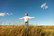 © Designpics - Young girl standing in a farm field with her arms outstretch and looking up to the warm sunlight; Alcomdale, Alberta, Canada