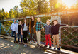 © Designpics - Family of seven standing on a bridge for a family portrait in a city park in autumn; Edmonton, Alberta, Canada