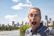 © Designpics - Senior man standing outdoors looking out over the top of his glasses at the camera with a surprised expression on his face; Edmonton, Alberta, Canada