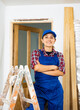 © JackF - Young woman builder posing next to a stepladder in a room being renovated