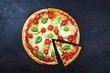 Traditionelle neapolitanisch italienische Pizza Margherita mit Tomaten und Mozzarella serviert als Draufsicht auf einem alten rustikalen Board mit Textfreiraum 