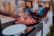 © .shock - A group of friends and family barbecue together in the evening on the terrace in front of a large modern house