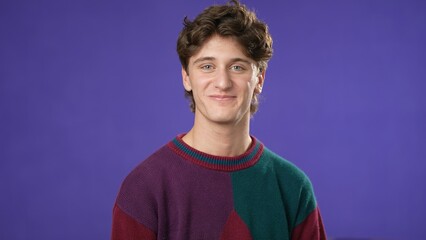 Portrait of smiling happy young hipster man 20s isolated on solid purple background with copy space in studio