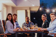 © .shock - A group of young diverse people having dinner on the terrace of a modern house in the evening. Fun for friends and family. Celebration of holidays, weddings with barbecue.