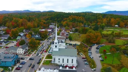 Wall Mural - Aerial pan across beautiful small Vermont town of Stowe in peak fall foliage with focus on church