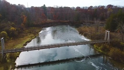 Poster - Aerial right up to suspension bridge over river in Michigan with late fall vibes