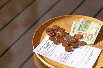 Wall Mural - Wooden plate with payment for order and receipt on table, closeup. Leave tip