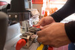 © Gan - Locksmith in workshop makes new key. Professional making key in locksmith. Machine production of duplicate metal key.