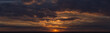 Landscape with bloody sunset. Panorama. Tragic gloomy sky. The last flashes of the sun on the storm clouds.