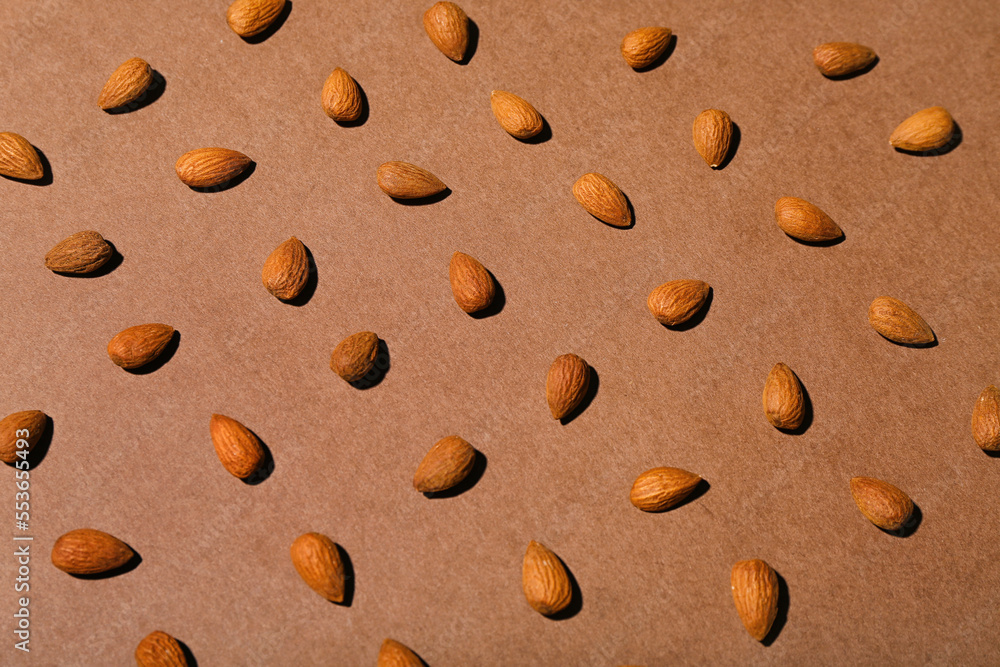 Many almonds on brown background
