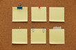 © tiena - Collection of empty pinned yellow memo papers on a corkboard background