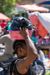 Scenes from the Haitian market near the border with Haiti. Unrecognizeable Haitian woman carrying a plastic bucket willed with goods on her head. 