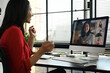 © Prathankarnpap - Side view of businesswoman having video call, discussing issues remotely online with diverse coworkers
