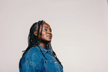 Woman with dreadlocks looking away thoughtfully in a studio