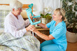Fürsorgliche Krankenpflegerin und Seniorin mit Krücken