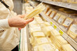 Customer holds pack of cheese and reads consumer information