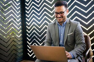 Wall Mural - Portrait of young successful businessman with digital device working in corporate business office