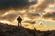 © Alberto - silhouette of a mountaineering couple hugging each other while hiking in the mountains with their dog at sunset. outdoor sports and adventure. weekend activities.
