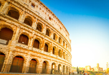 Wall Mural - famous ruins of Colosseum and street at sunrise in Rome, Italy