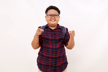 Wall Mural - Happy asian school boy standing while pointing at the camera. Isolated on white background