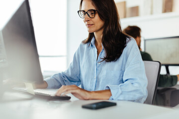 Poster - Female software developer working on a computer in an office