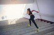 © Panumas - Young woman running sprinting up stairs at stadium. Fit runner fitness runner during outdoor workout. Selected focus