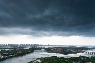 Wall Mural - Dark clouds over a city by the sea