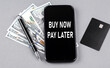 © Iryna - Credit card and text BUY NOW - PAY LATER on smartphone with dollars and pen. Business concept