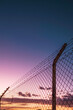 © Marcos - cross-border fence at sunset.border between countries.