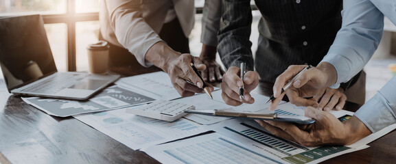 Business People Meeting using laptop computer,calculator,notebook,stock market chart paper for analysis Plans to improve quality next month. Conference Discussion Corporate Concept.