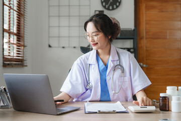 Portrait of female Asian doctor working with patient document in her office at clinic