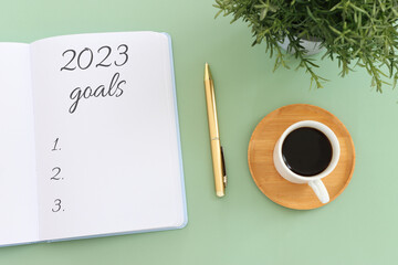 Wall Mural - Business concept of top view 2023 goals list with notebook, cup of coffee over wooden desk