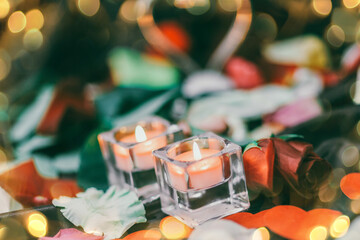 two candles on the dark festive table. Beautiful bokeh effect from a garland.