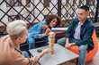 © zinkevych - Three friends playing a board game on the veranda