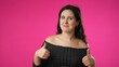 © Robert Peak - Portrait of happy, young hipster woman 20s point finger at herself, feeling good giving thumbs up isolated on pink background in studio