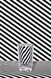 © ADDICTIVE STOCK - Glass of water against striped black and white background