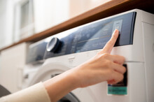 Close-up Woman Hand Pushing Washing Machine Buttons For Setting Program Or Start Laundry  , Health Care Lifestyle Concept