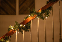 Garland And Lights Wrapped Around Handrail On Stairs For Christmas 