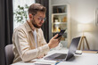 © MYDAYcontent - Businessman working from home, checking messages on the smartphone. Staying in touch with colleagues.