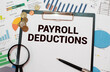 Selective focus.Calculator,pencil and banknotes with the word Payroll Deduction on world map background.