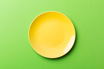 Wall Mural - Top view of isolated of colored background empty round yellow plate for food. Empty dish with space for your design