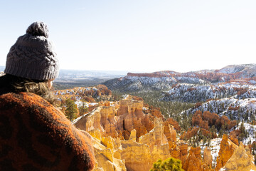 out of focus vertical image of young woman overlooking in focus Bryce canyon national park amphitheater with hoodoos in distance