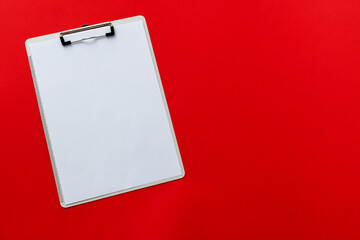 Wall Mural - Clipboard with a paper on red background