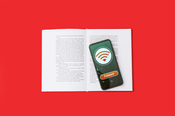 Wall Mural - Opened book and mobile phone with WiFi symbol on color background