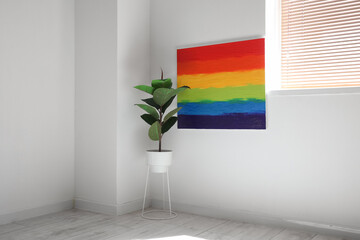 Poster - Houseplant and painting of LGBT flag hanging on light wall in room