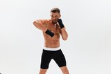 Fototapeta Przeznaczenie - Man athletic bodybuilder poses in boxing gloves with nude torso abs in full-length background, boxing and martial arts. Advertising, sports, active lifestyle, competition, challenge concept. 